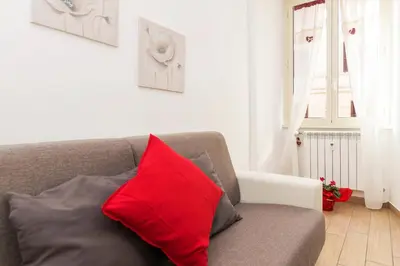 a red pillow sitting on a couch in a living room at Amor Vatican Domus in Rome