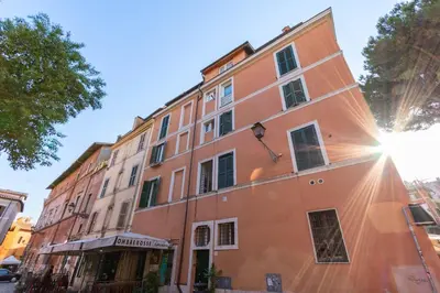 an orange building with the sun shining on it at Magenta Collection Egidio in Rome