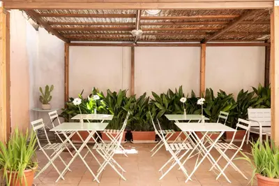 two tables and chairs in a greenhouse with plants at Hotel Parker - Gruppo BLAM HOTELS in Rome