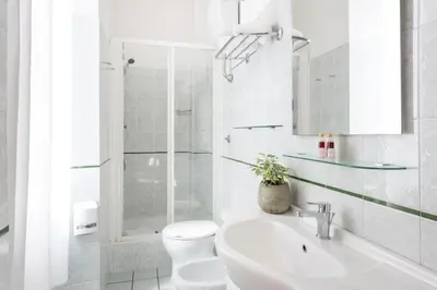 a white bathroom with a toilet and a sink at Hotel Parker - Gruppo BLAM HOTELS in Rome