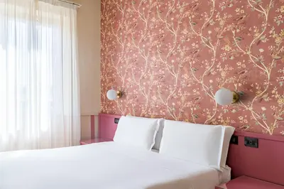 a bedroom with a white bed and a pink wall at Hotel Parker - Gruppo BLAM HOTELS in Rome