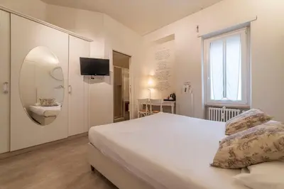 a bedroom with a bed and a mirror and a sink at Nina Casetta De Trastevere in Rome