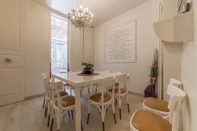 a dining room with a white table and chairs at Nina Casetta De Trastevere in Rome