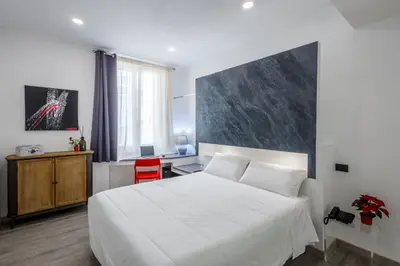 a bedroom with a white bed and a red chair at Crossroad Hotel in Rome