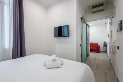 a white bed with two towels on top of it at Crossroad Hotel in Rome