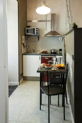 a small kitchen with a table and a stove at Casa Tua a Piazza del Popolo in Rome