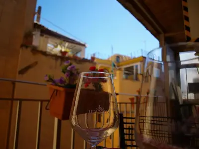 a glass of wine sitting on a balcony at Casa Tua a Piazza del Popolo in Rome