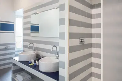 two sinks in a bathroom with striped walls at Residenza Termini in Rome