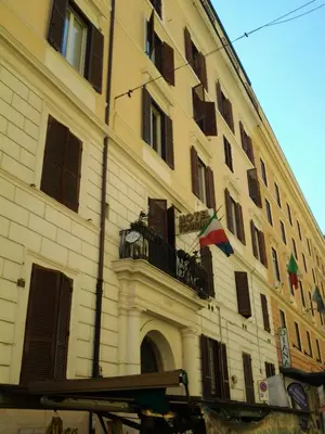 a large building with a balcony and flags on it at Hotel Touring in Rome