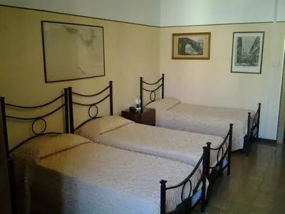 a room with three beds in a room at Hotel Touring in Rome