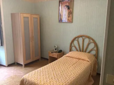 a hotel room with a bed and a dresser and a bed and a bed at Hotel Touring in Rome
