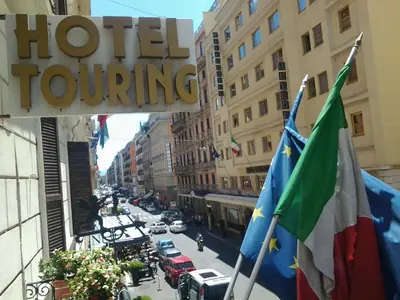 a street with two flags and a hotel touring sign at Hotel Touring in Rome