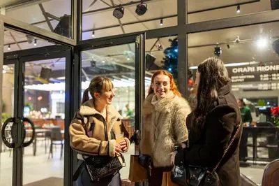 three women standing in front of a store window at hu Roma Camping In Town in Rome