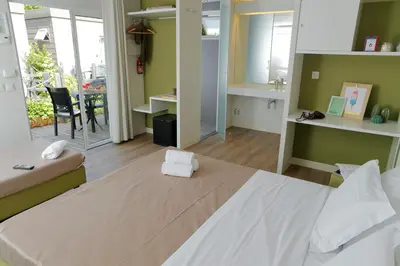 a bedroom with a large bed and a dining room at hu Roma Camping In Town in Rome