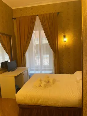 a bedroom with a bed and a desk and a window at DCBoutiqueHotel in Rome
