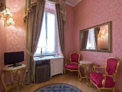 a living room with pink walls and a window and chairs at DCBoutiqueHotel in Rome