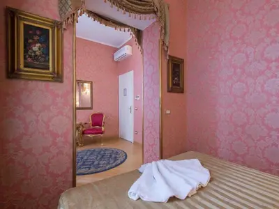 a bedroom with pink walls and a mirror and a bed at DCBoutiqueHotel in Rome