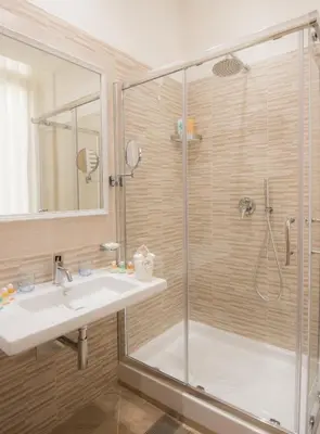 a bathroom with a glass shower and a sink at Esposizione Palace Hotel in Rome