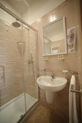 a bathroom with a sink and a shower with a mirror at Esposizione Palace Hotel in Rome