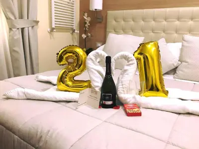 a bed with gold balloons and a bottle of champagne at Esposizione Palace Hotel in Rome