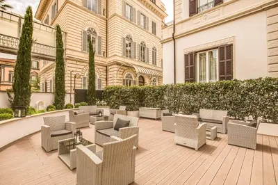 a patio with chairs and tables in front of a building at The Liberty Boutique Hotel in Rome