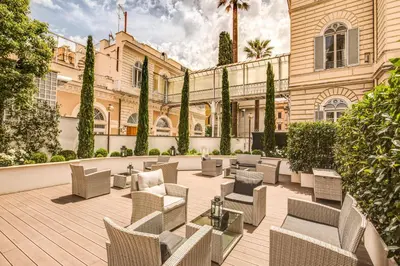 a patio with chairs and tables in front of a building at The Liberty Boutique Hotel in Rome