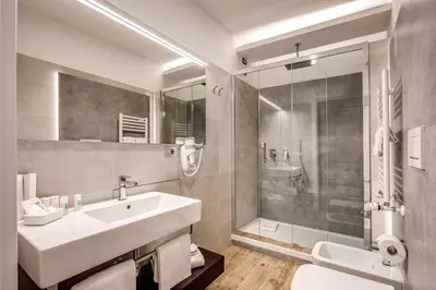 a white bathroom with a sink and a shower at The Liberty Boutique Hotel in Rome