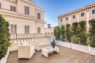 a balcony with chairs and a table on a building at The Liberty Boutique Hotel in Rome