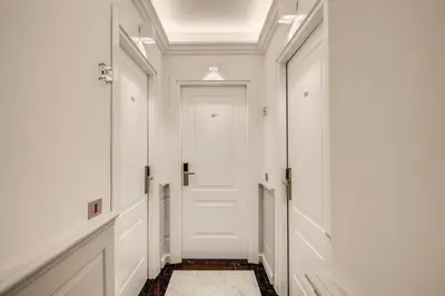 a hallway with white walls and a white door at The Liberty Boutique Hotel in Rome