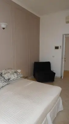 a bedroom with a white bed and a black chair at Camera Con Vista in Rome