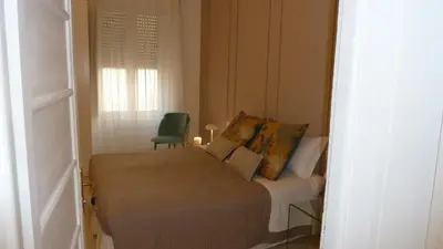 a small bedroom with a bed and a green chair at Camera Con Vista in Rome