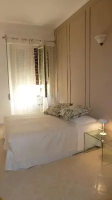 a white bedroom with a bed and a window at Camera Con Vista in Rome