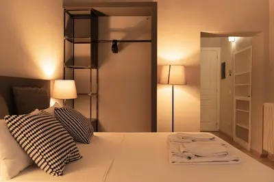 a bedroom with a bed with two lamps and a mirror at TrastevereInn in Rome