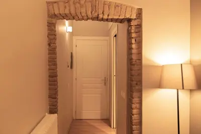 an archway in a hallway with a lamp and a door at TrastevereInn in Rome