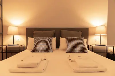 a bedroom with a large bed with two white towels on it at TrastevereInn in Rome