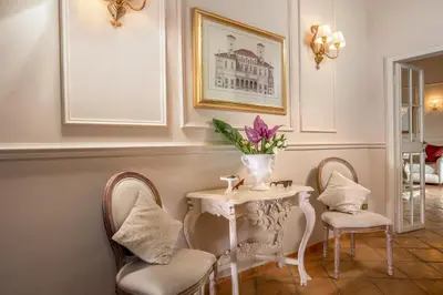 a table with two chairs and a vase with flowers on it at Trevi Ab Aeterno - Amazing View of the Trevi Fountain in Rome