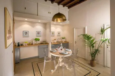 a kitchen with a table and chairs in a room at Trevi Ab Aeterno - Amazing View of the Trevi Fountain in Rome