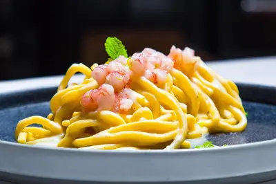 a plate of pasta with shrimp on top of it at iQ Hotel Roma in Rome