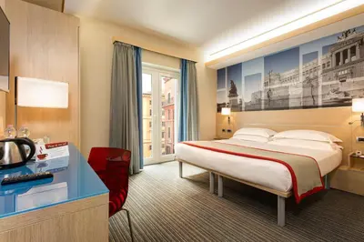 a hotel room with a bed and a television at iQ Hotel Roma in Rome