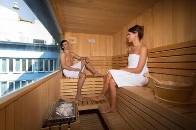 a man and woman sitting in a sauna at iQ Hotel Roma in Rome