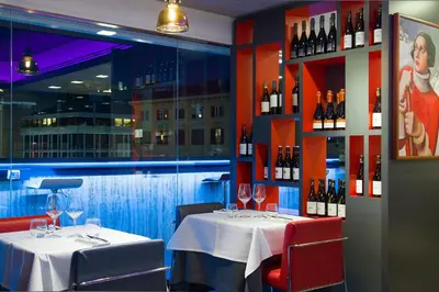 a dining room with two tables with wine bottles at iQ Hotel Roma in Rome