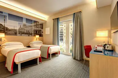 a hotel room with three beds and a window at iQ Hotel Roma in Rome