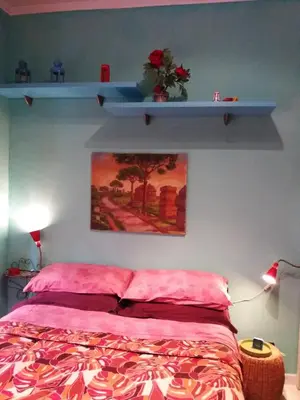 a bedroom with a bed and a shelf on the wall at Anna Vì Guest Home in Rome