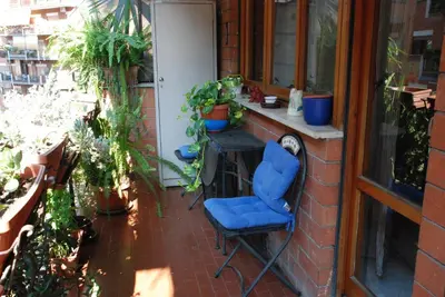 a blue chair sitting on a patio with plants at Anna Vì Guest Home in Rome