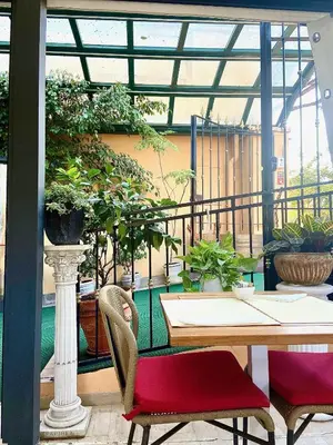 a table and chairs in a room with plants at Sourire Hotel in Rome