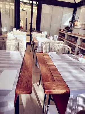 a restaurant with wooden tables and white chairs at Sourire Hotel in Rome