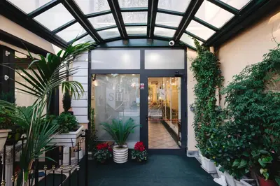 an entrance to a store with plants and a glass door at Sourire Hotel in Rome
