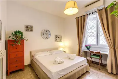 a bedroom with a bed and a desk and a clock at Cuore di Florio Apartment in Rome