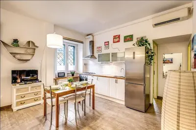 a kitchen with a table and a refrigerator at Cuore di Florio Apartment in Rome