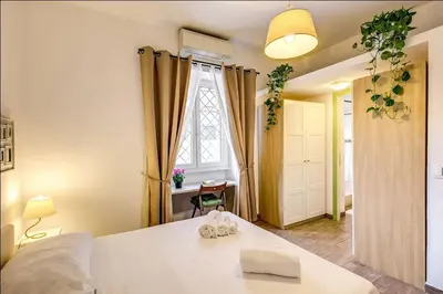 a bedroom with a large white bed and a window at Cuore di Florio Apartment in Rome
